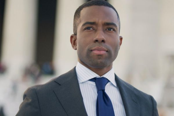 Shermichael Singleton in a charcoal suit and navy tie